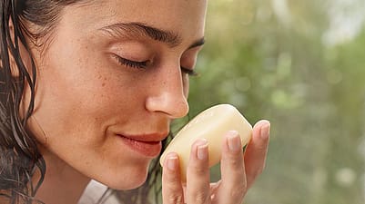 Woman smelling a soap bar.