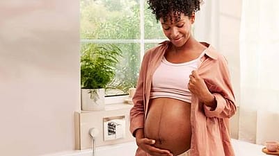 mujer embarazada sonriendo tocandose la tripa