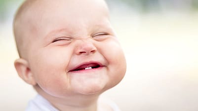 Baby with two bottom teeth grinning
