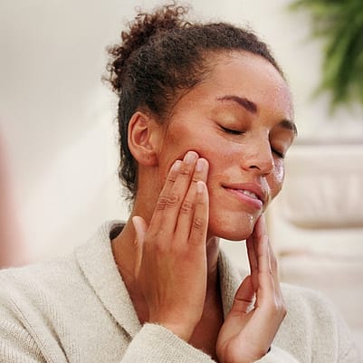 kvinna smörjer in ansiktet