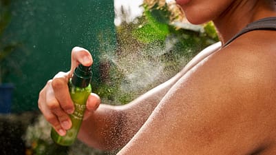 donna che applica lo spray idratante