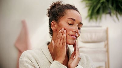 Kvinna masserar ansiktet