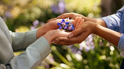 cuatro manos sujetando flores de genciana azul y edelweis