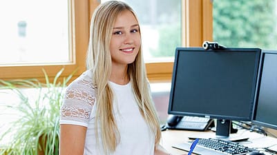 Frau am Bürotisch vor dem Computer