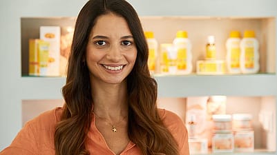 Frau im Büro mit Weleda Produkten im Hintergrund