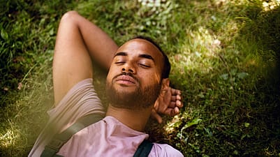 Mann in der Wiese mit geschlossenen Augen