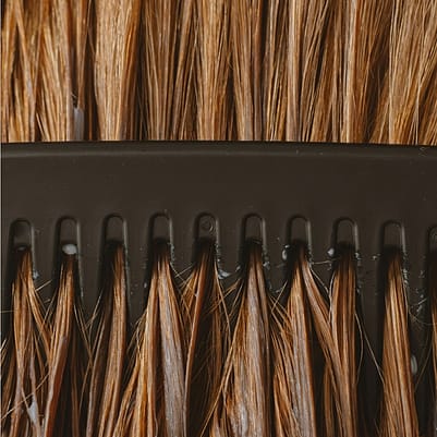 cabello siendo peinado por un cepillo