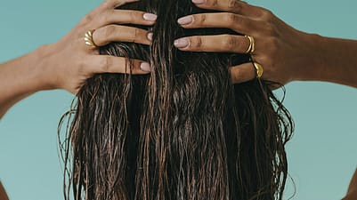 Frau fasst sich in die Haare