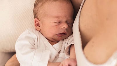 Le bébé dort dans les bras de sa mère
