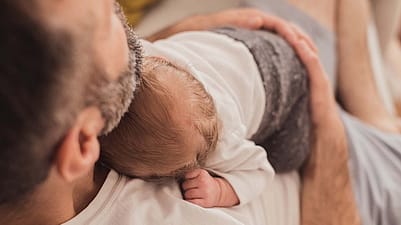 le bébé est allongé sur son père