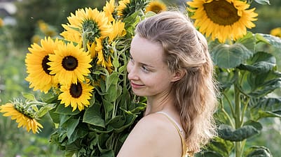 woman holding sun flowers