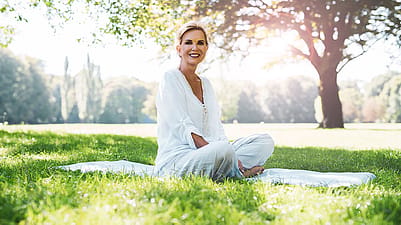 An older woman sitting relaxed in the park