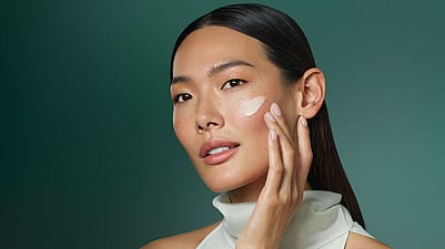 Frau wendet Creme im Gesicht an