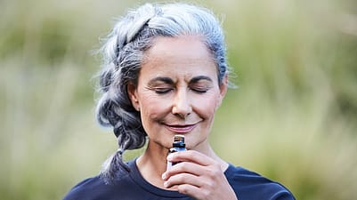 zralá žena v přírodě čichá k vůni
