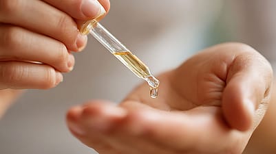 Mani con pipetta di olio