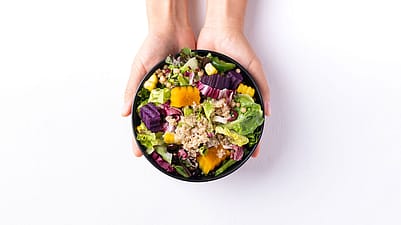 Two women sitting next to eachother and eating.