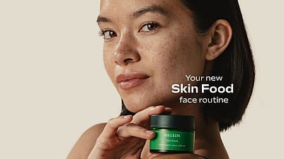 Kvinna håller i en burk med weleda skin food dagkräm