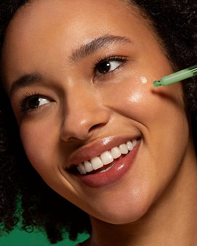 Woman applying face serum in dropper