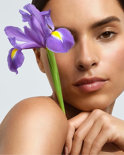 Woman holding iris in front of face