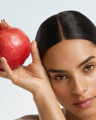 Female holding pomegranate fruit
