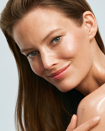 Woman smiling applying body oil