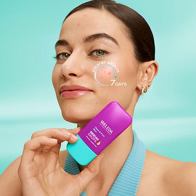 Model is holding Clear & Pure Skin Booster Serum Drops in front of face