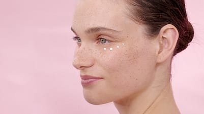 Frau wendet Augencreme an