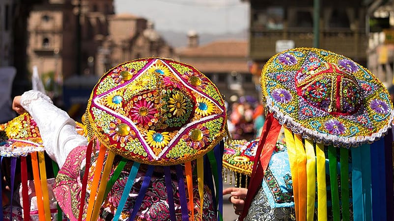 Persone con sombreri colorati e a fiori durante una celebrazione al sole