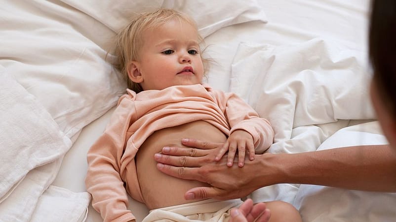 manos haciendo masaje de vientre a bebe