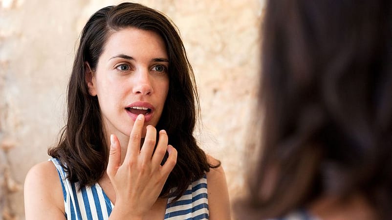 Junge Frau trägt Lippenpflege auf