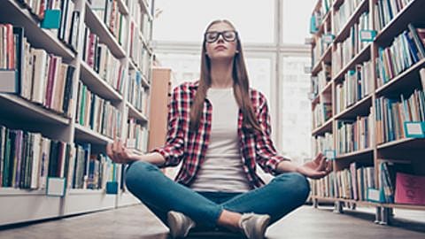 femme meditant dans une bibliothèque