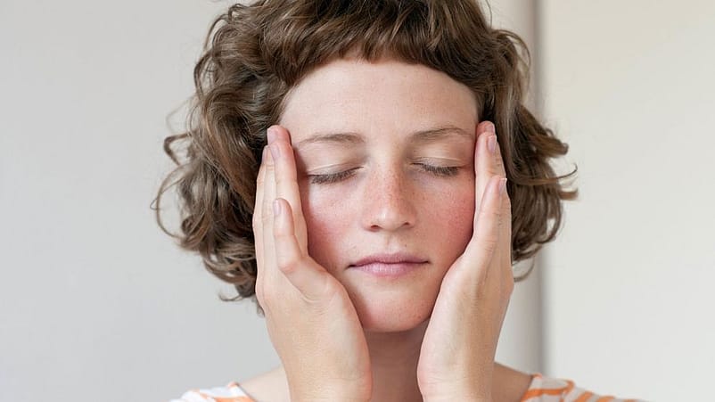 Una giovane donna applica la crema massaggiando dal contorno occhi verso le tempie