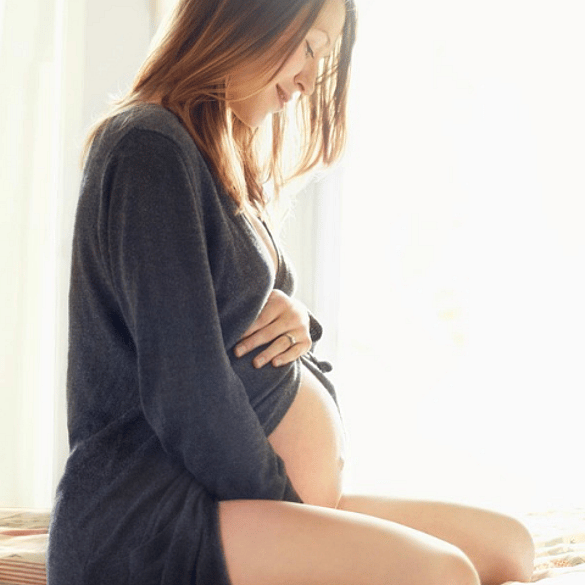 mujer embarazada sonriendo tocandose la tripa
