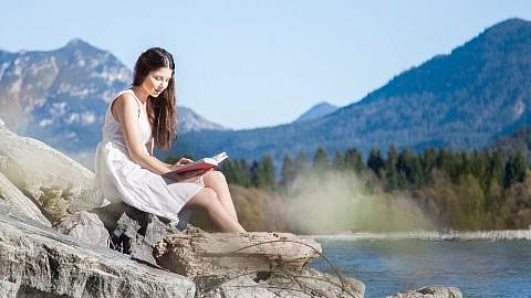 Femme assise au bord de la rivière