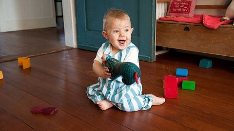 bebe sujetando un juguete en las manos