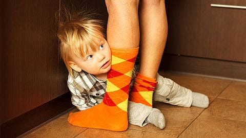 niño escondido entre los pies de su padre