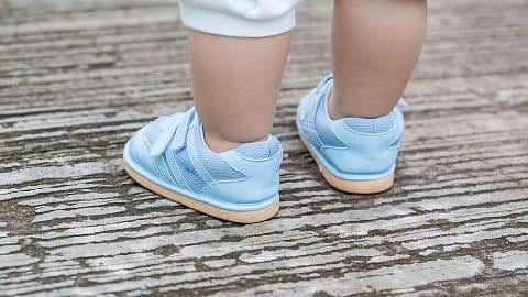 piernas de un niño pequeño con zapatos