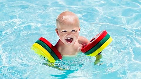 bebé en la piscina con un flotador