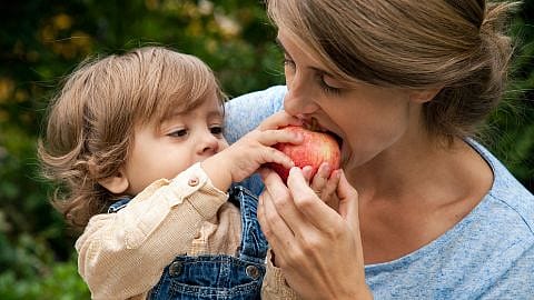 niño dándole de comer a su madre