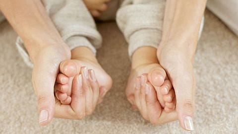 madre dando un masaje en los pies de su bebé