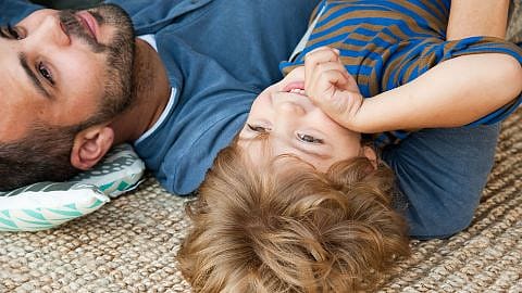 padre e hijo tumbados en el suelo
