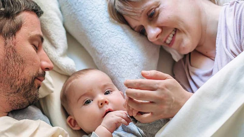 mamma papà e figlio sono nel letto. Il papà dorme, il figlio e la mamma no