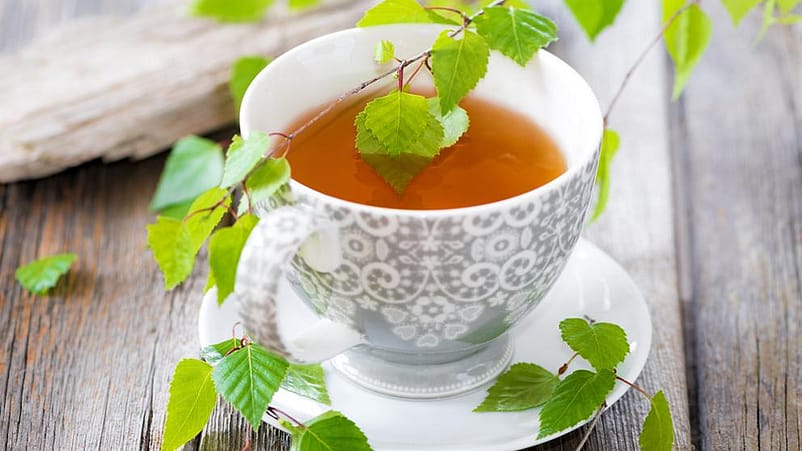 Eine Tasse Tee und Birkenblätter