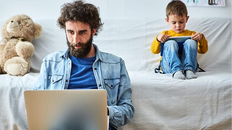 Père et fils devant des ordinateurs portables