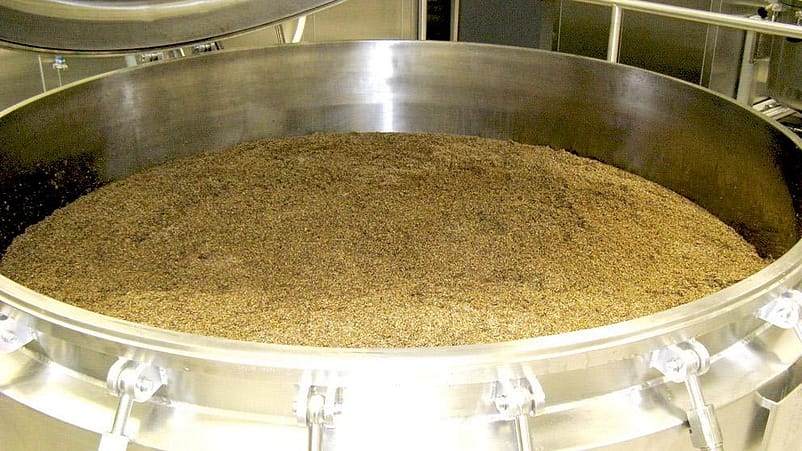 Pflanzenteile werden in einem grossen Metallbottich ausgekocht