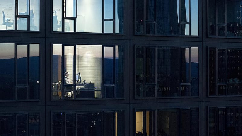 esterno di un palazzo, all'interno un signore lavora al computer