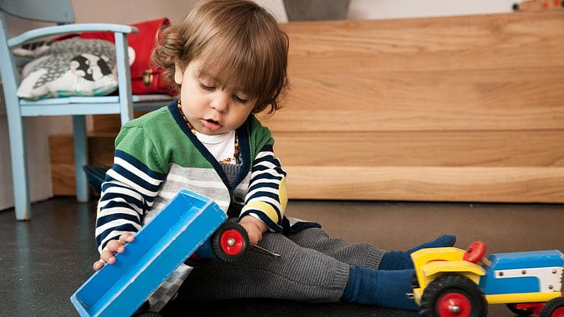 niño jugando en el suelo con juguetes