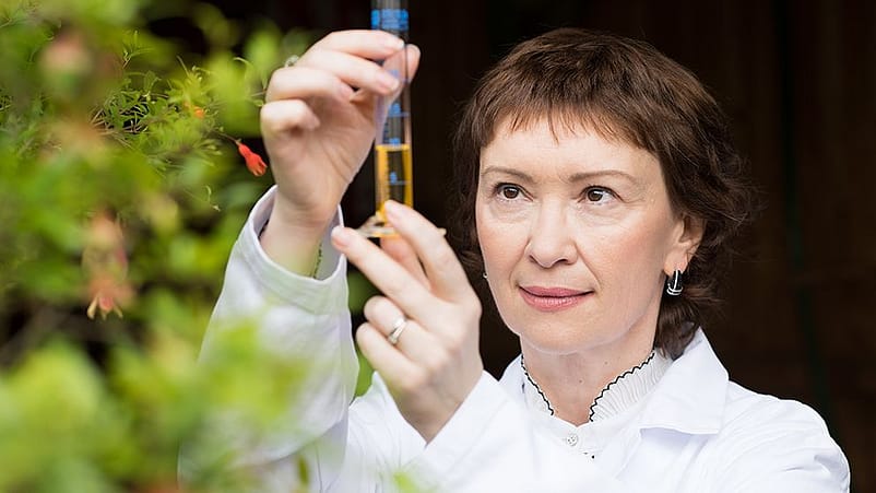 Donna tiene in mano misurino con un olio naturale controllando i giusti ml