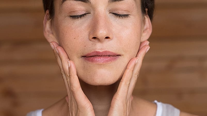 Kvinna smörjer ansiktet