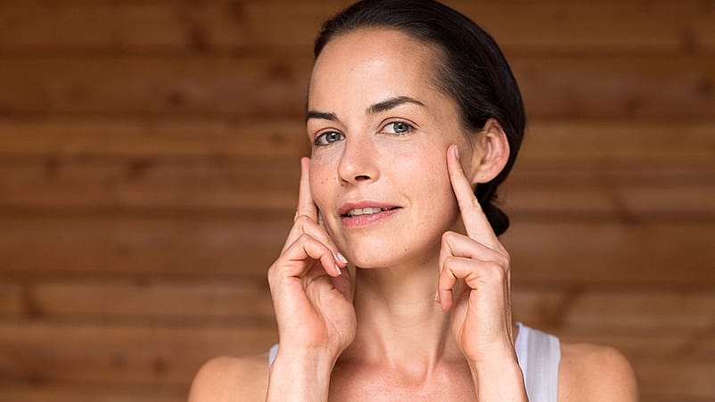 Kvinna smörjer in ansiktet